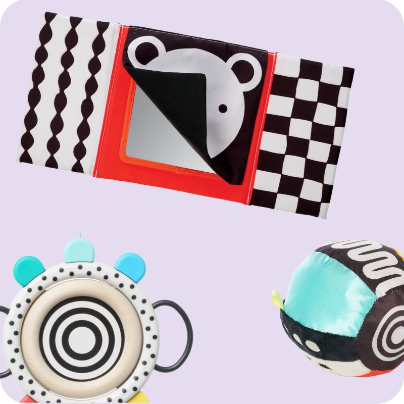 3 black and white high contrast infant toys, a ball mirror toy and wood grasping toy on a soft pink background